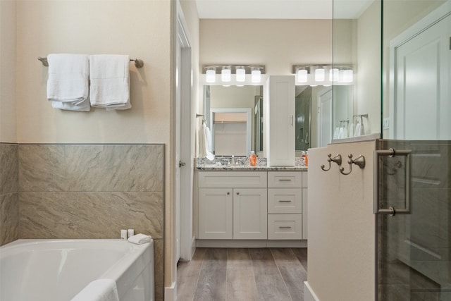 bathroom with wood-type flooring, separate shower and tub, and vanity