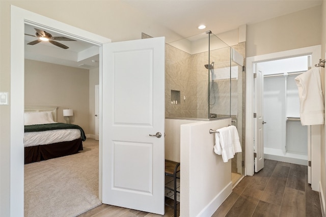 bathroom featuring a shower with shower door, ceiling fan, and hardwood / wood-style flooring