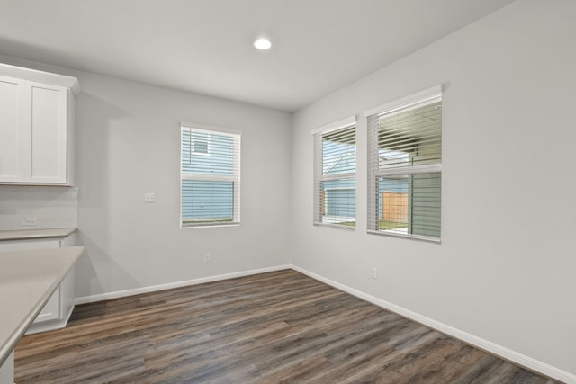 unfurnished dining area featuring dark wood-type flooring