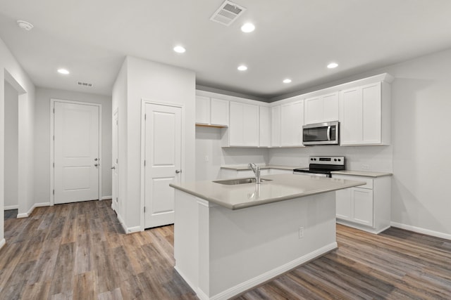 kitchen with appliances with stainless steel finishes, hardwood / wood-style flooring, white cabinetry, sink, and an island with sink