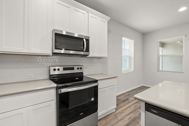 kitchen featuring decorative backsplash, white cabinetry, appliances with stainless steel finishes, and light wood-type flooring