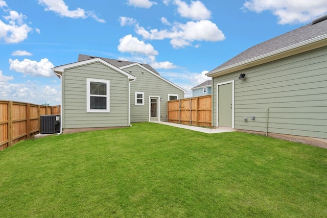 rear view of property featuring a yard and central AC