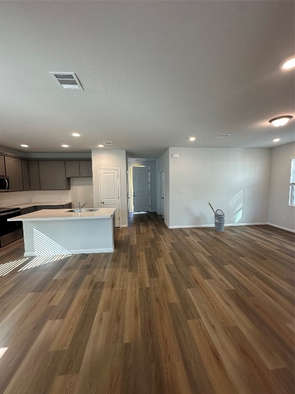 kitchen featuring a kitchen island with sink, sink, stainless steel appliances, and dark hardwood / wood-style floors