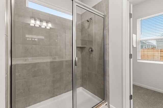 bathroom featuring a shower with door