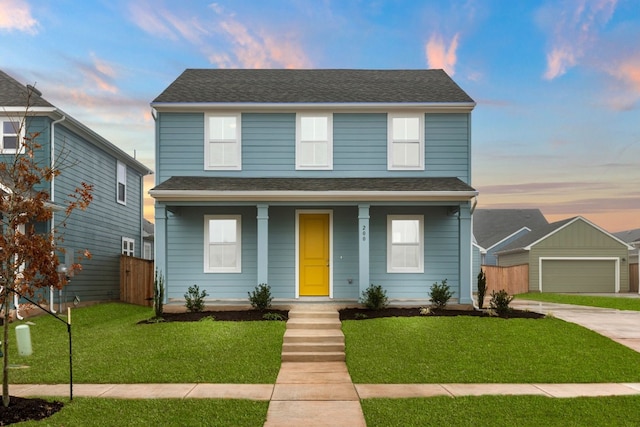 view of front of property featuring a garage, a yard, an outdoor structure, and covered porch