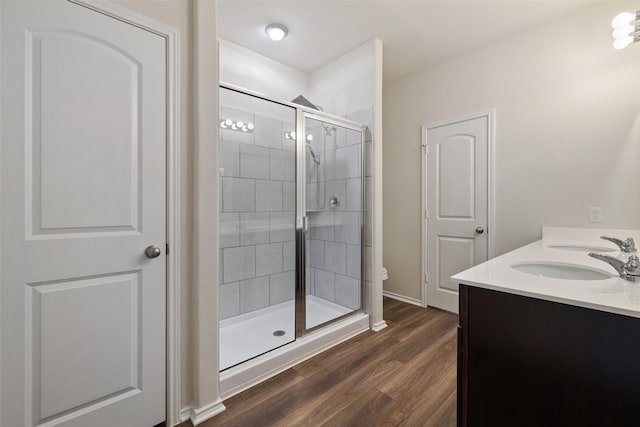 bathroom with hardwood / wood-style flooring, vanity, toilet, and walk in shower