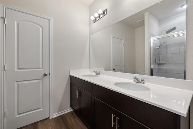 bathroom with hardwood / wood-style flooring, an enclosed shower, and vanity