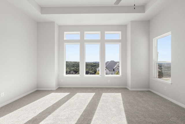 carpeted empty room featuring plenty of natural light and ceiling fan