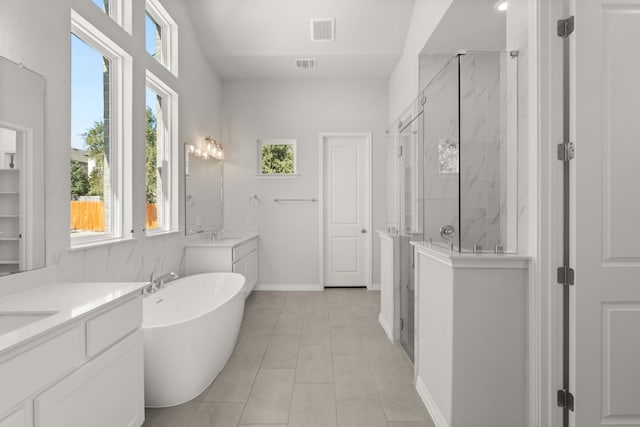 bathroom featuring tile patterned flooring, vanity, and separate shower and tub