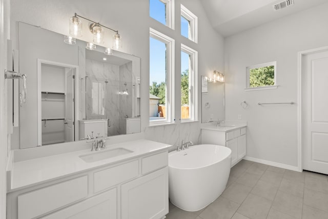 bathroom with tile patterned floors, vanity, plus walk in shower, and vaulted ceiling