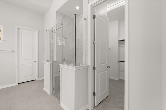 bathroom with tile patterned floors and a shower with door