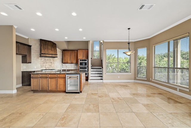 kitchen with beverage cooler, a sink, visible vents, and custom range hood