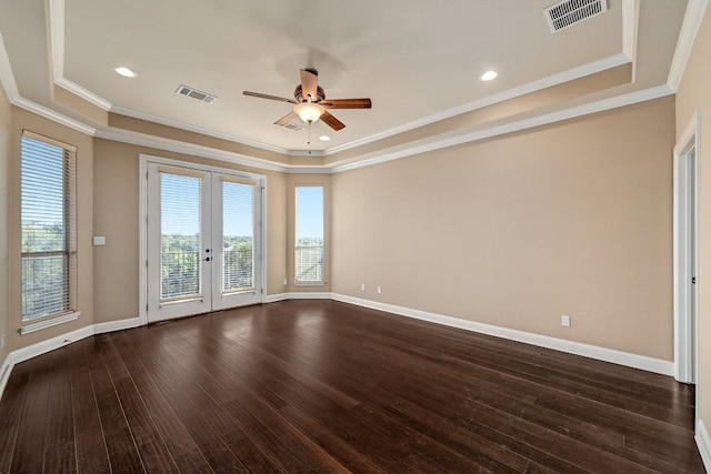 unfurnished room featuring ceiling fan, a tray ceiling, dark hardwood / wood-style flooring, crown molding, and french doors