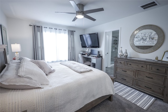 bedroom featuring ceiling fan, connected bathroom, and dark carpet