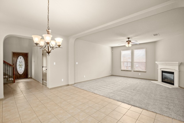 unfurnished living room featuring light carpet and ceiling fan with notable chandelier