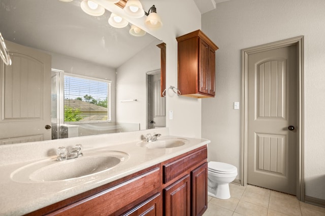 bathroom with toilet, vanity, tile patterned floors, and vaulted ceiling