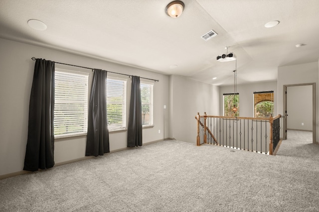 carpeted empty room featuring vaulted ceiling