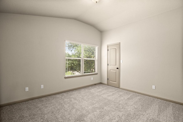 empty room with light carpet and vaulted ceiling