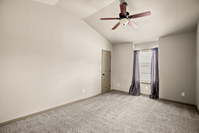 carpeted spare room with ceiling fan and vaulted ceiling