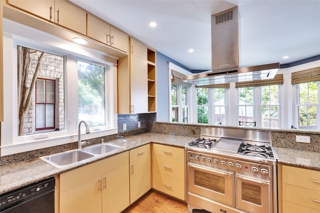 kitchen featuring light wood-type flooring, dishwasher, sink, island exhaust hood, and range with two ovens