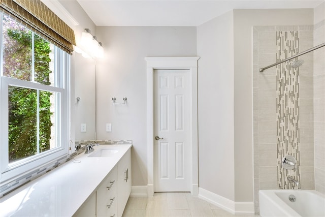 bathroom featuring a wealth of natural light, tile patterned floors, tiled shower / bath, and vanity