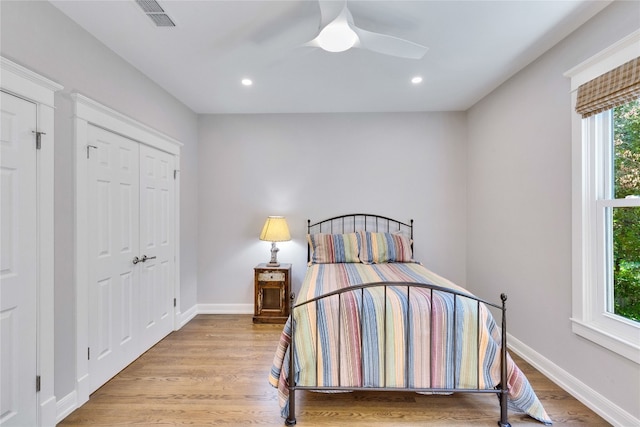 bedroom with light hardwood / wood-style flooring, a closet, and ceiling fan