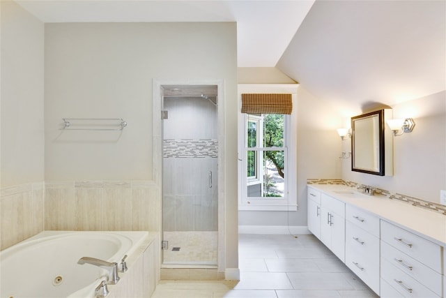 bathroom with tile patterned flooring, independent shower and bath, vanity, and vaulted ceiling