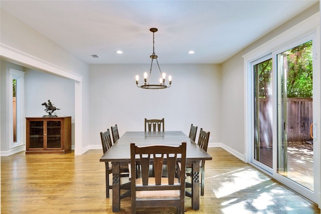 dining area featuring light hardwood / wood-style floors and an inviting chandelier