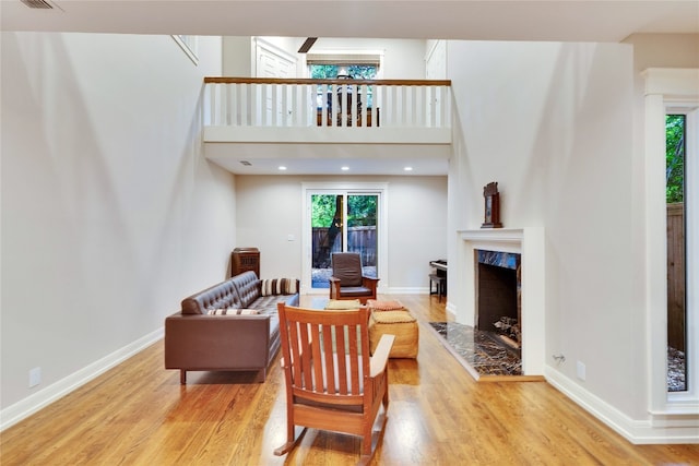 living room featuring light wood-type flooring and a high end fireplace