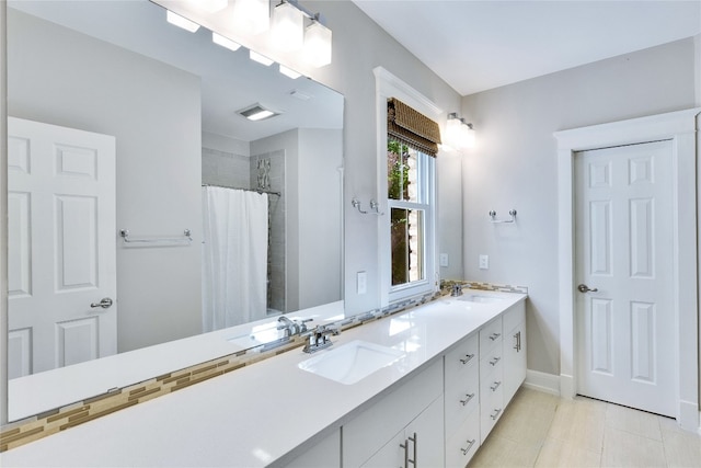 bathroom featuring tile patterned floors, vanity, and curtained shower