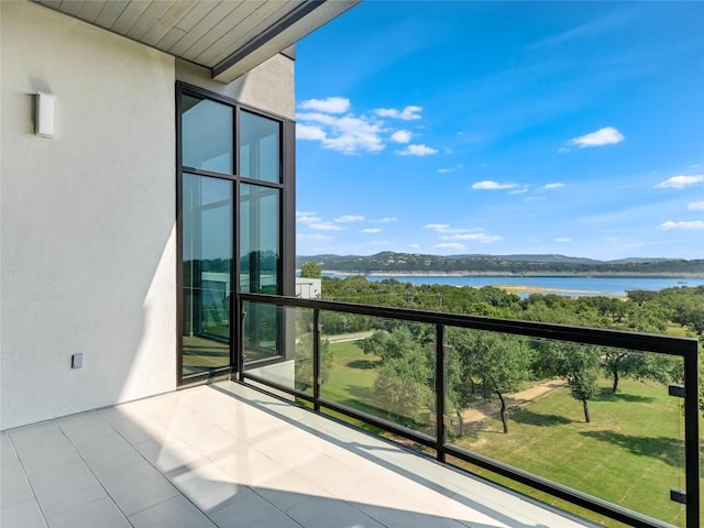 balcony featuring a water and mountain view