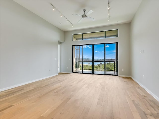 spare room with track lighting, light hardwood / wood-style flooring, and ceiling fan