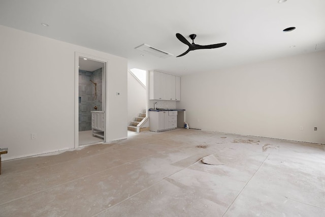 spare room featuring a ceiling fan, visible vents, and stairs