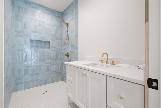 full bathroom with tiled shower and vanity