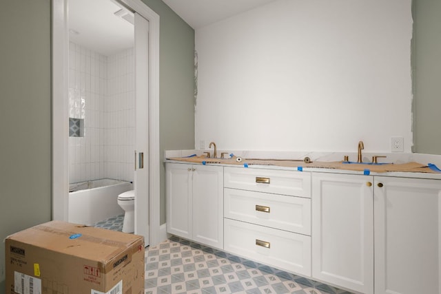 bathroom featuring toilet, a sink, and tile patterned floors