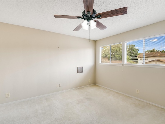 carpeted empty room featuring ceiling fan and a textured ceiling