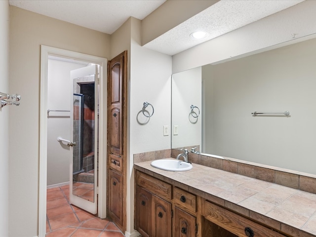 bathroom with tile patterned flooring, a textured ceiling, and vanity