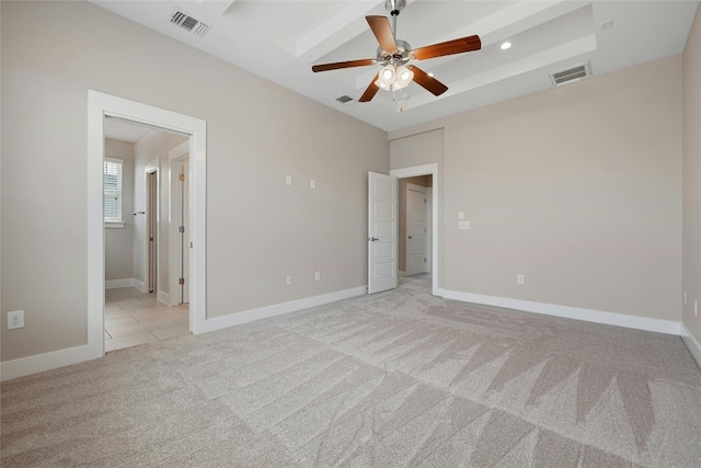 unfurnished bedroom featuring ceiling fan, ensuite bath, and light colored carpet