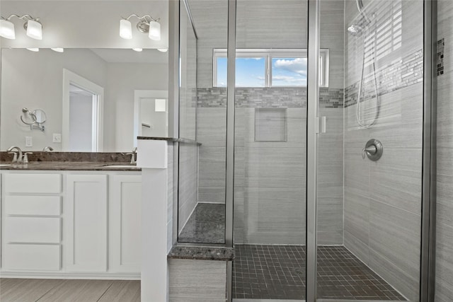 bathroom featuring walk in shower, vanity, and tile floors