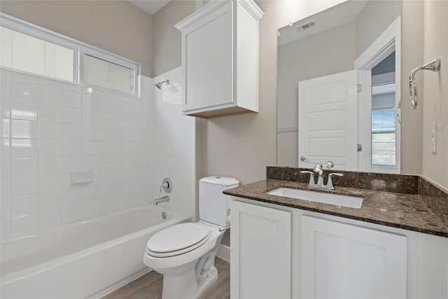 full bathroom featuring toilet, tiled shower / bath, oversized vanity, and hardwood / wood-style floors