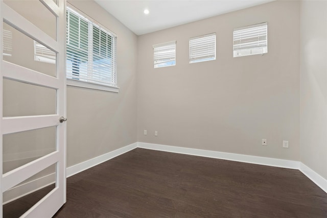 unfurnished room with dark hardwood / wood-style flooring