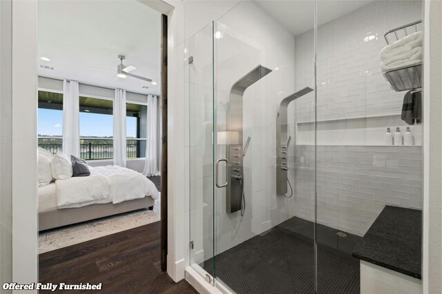 bathroom with hardwood / wood-style floors, ceiling fan, and a shower with shower door