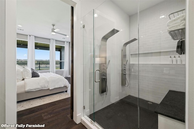 ensuite bathroom with ensuite bathroom, ceiling fan, wood finished floors, visible vents, and a shower stall