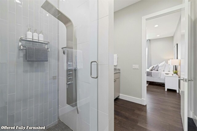 bathroom with wood-type flooring, vanity, and an enclosed shower