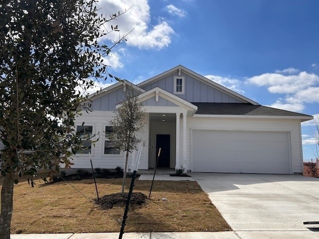 view of front facade with driveway, board and batten siding, and an attached garage