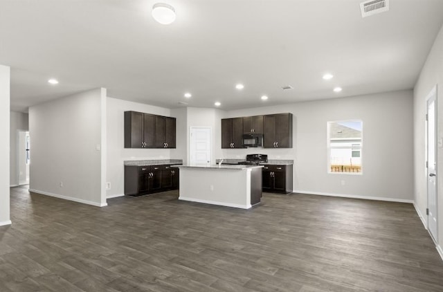 kitchen with visible vents, dark brown cabinets, open floor plan, and black microwave