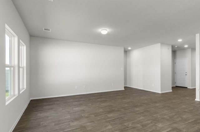 empty room with recessed lighting, visible vents, plenty of natural light, and dark wood-style floors