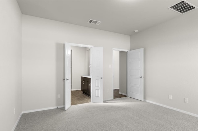 unfurnished bedroom featuring visible vents, baseboards, and carpet flooring