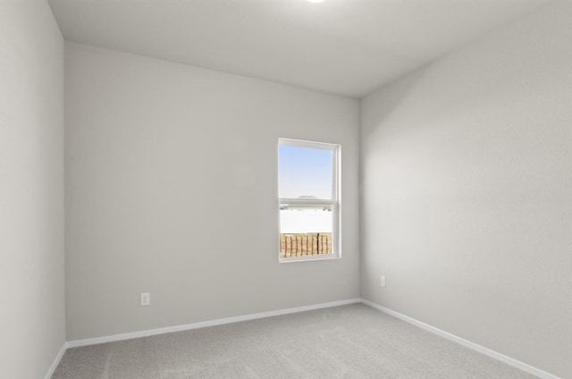 empty room with baseboards and light carpet