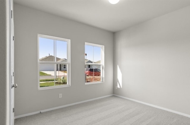 carpeted empty room featuring baseboards